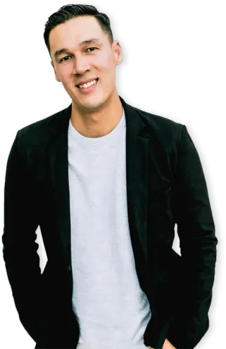 Brandon Lee, Creative Director, smiling with his hands in the pockets of a dark blazer