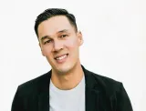 Portrait of a smiling man in a dark blazer and grey t-shirt
